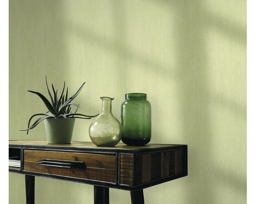 Nature morte décorative avec plante, vases et console devant un mur