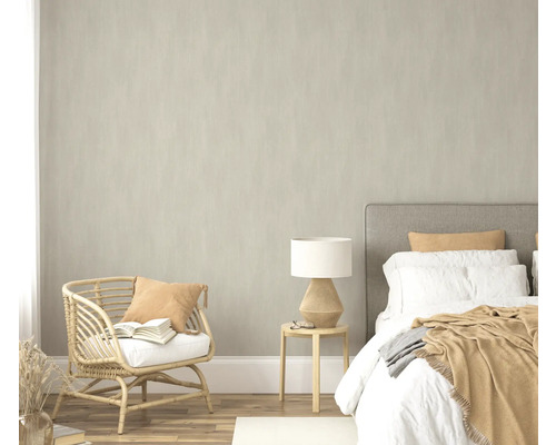 Chambre avec lit, table d'appoint, lampe et fauteuil en rotin