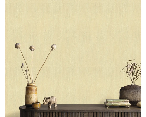 Gros plan d'un mur avec un papier peint de couleur claire et des objets décoratifs sur une étagère en bois foncé.