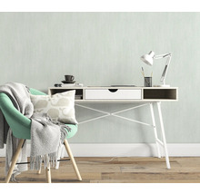 Helles Arbeitszimmer mit Schreibtisch, Schreibtischlampe, Stuhl, Kissen und Decke für eine freundliche Atmosphäre.