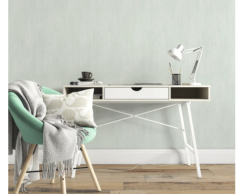 Helles Arbeitszimmer mit Schreibtisch, Schreibtischlampe, Stuhl, Kissen und Decke für eine freundliche Atmosphäre.