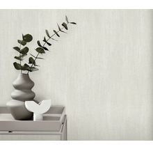 Gros plan d'un papier peint clair et texturé avec un vase de plantes sur une table