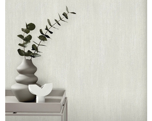 Gros plan d'un papier peint clair et texturé avec un vase de plantes sur une table
