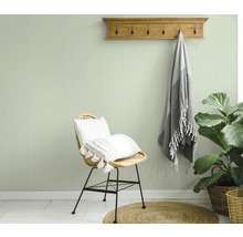 Vue d'une pièce avec du papier peint à chevrons, une chaise, un tabouret et une plante d'intérieur