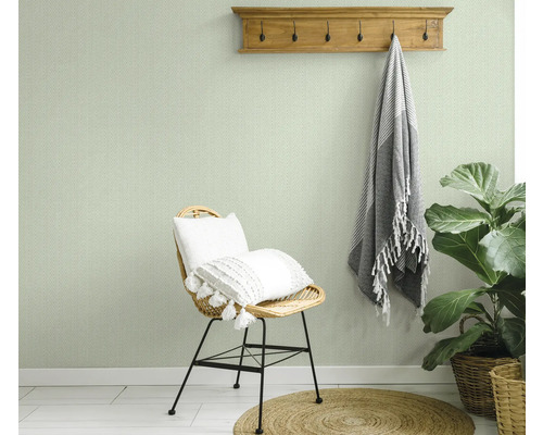 Vue d'une pièce avec du papier peint à chevrons, une chaise, un tabouret et une plante d'intérieur