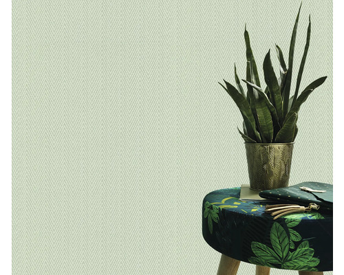 Papier peint clair à chevrons à côté d'un tabouret à motifs de feuilles et d'une plante d'intérieur