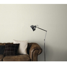 Papier peint à motifs au-dessus d'un canapé en cuir marron avec lampadaire
