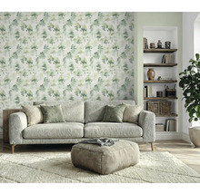 Salon avec canapé, tabouret, tapis, étagère à livres et papier peint à motif d'arbres pour une ambiance chaleureuse
