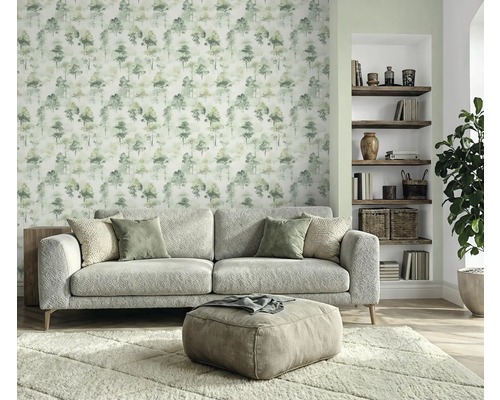Salon avec canapé, tabouret, tapis, étagère à livres et papier peint à motif d'arbres pour une ambiance chaleureuse