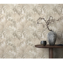 Papier peint à motif de feuilles derrière une table en bois avec décoration