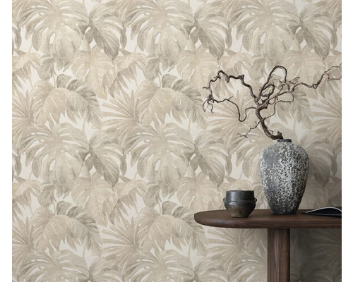 Papier peint à motif de feuilles derrière une table en bois avec décoration