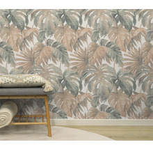 Pièce avec un papier peint à motifs de feuilles tropicales, un banc avec coussin et une couverture roulée.