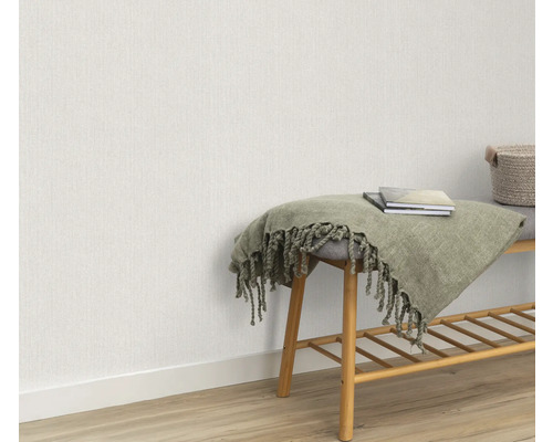 Scène avec papier peint intissé clair, banc avec étagère, couverture et livres.