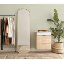 Vue d'une pièce avec portant, miroir, commode et plante