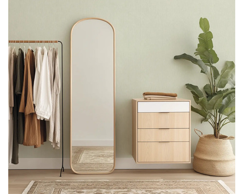 Vue d'une pièce avec portant, miroir, commode et plante