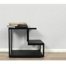 Table d'appoint noire à trois étagères avec des livres dessus