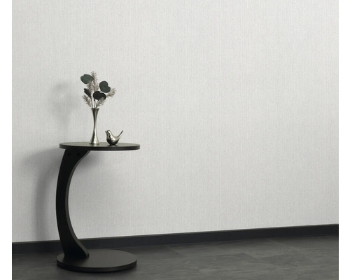 Papier peint à structure claire sur le mur avec décoration sur une table d'appoint