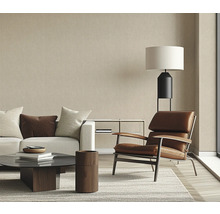 Salon avec canapé, fauteuil, table basse et lampadaire dans un design lumineux.