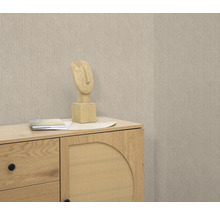 Scène avec commode, sculpture décorative et papier peint beige