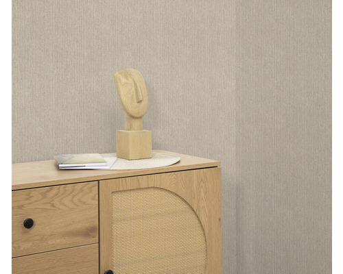 Scène avec commode, sculpture décorative et papier peint beige