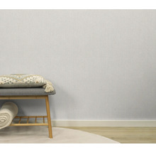 Papier peint clair et structuré dans la pièce, combiné avec un tabouret et des éléments décoratifs.