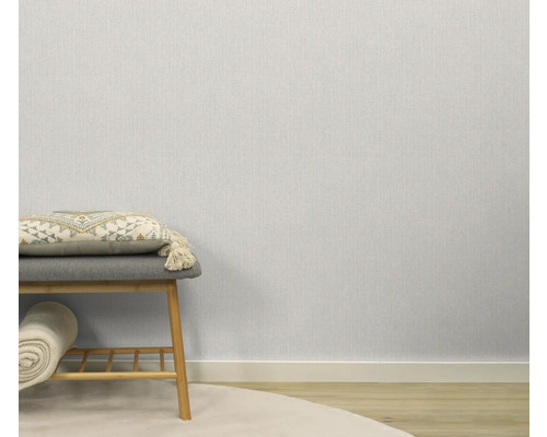 Papier peint clair et structuré dans la pièce, combiné avec un tabouret et des éléments décoratifs.