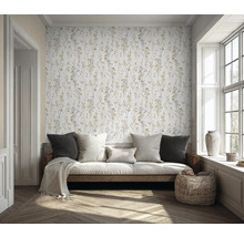 Pièce claire avec canapé, coussins, panier en osier et papier peint à motifs floraux