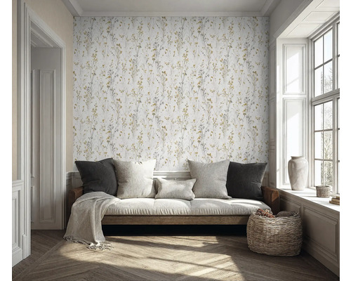 Pièce claire avec canapé, coussins, panier en osier et papier peint à motifs floraux