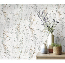 Papier peint à motifs floraux délicats et divers objets de décoration sur une commode.
