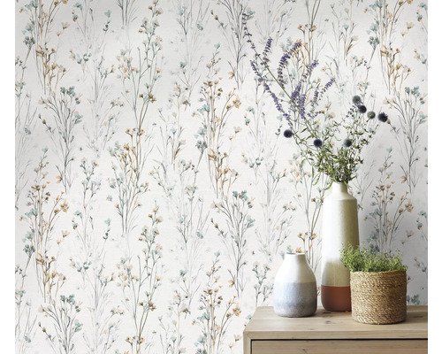 Papier peint à motifs floraux délicats et divers objets de décoration sur une commode.