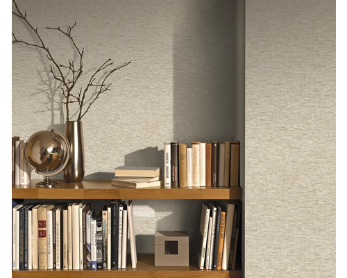 Étagère avec livres et objets de décoration devant un papier peint à motifs