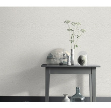 Scène avec un papier peint blanc à motif de pierre et une table d'appoint avec des objets décoratifs