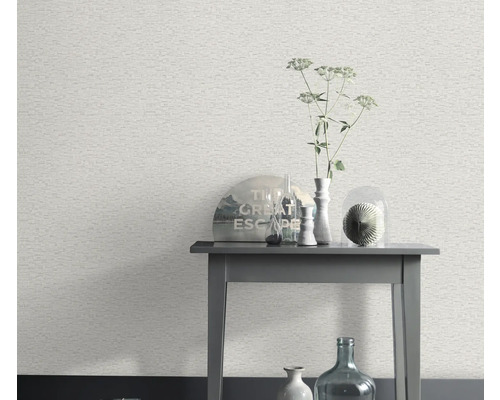 Scène avec un papier peint blanc à motif de pierre et une table d'appoint avec des objets décoratifs