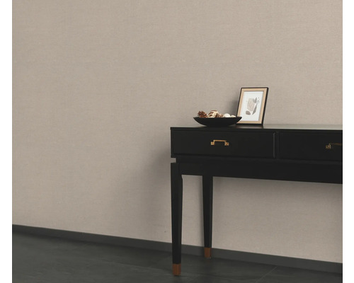 Console noire avec décoration et image sur un mur beige
