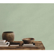 Papier peint avec structure textile devant une décoration avec un vase et un bol