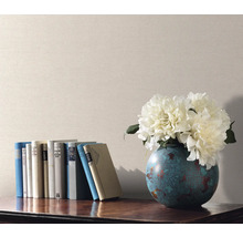Scène décorative avec des livres, un vase de fleurs et du papier peint uni