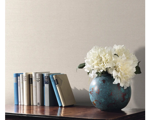 Scène décorative avec des livres, un vase de fleurs et du papier peint uni