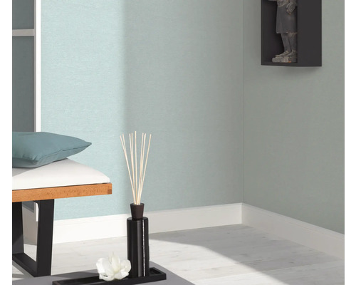 Gros plan d'un espace de vie décoré avec une banquette, des bâtonnets parfumés et une décoration murale