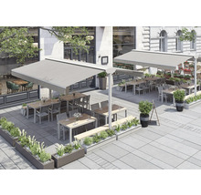 Terrasse extérieure d'un restaurant avec stores, tables, chaises et plantations