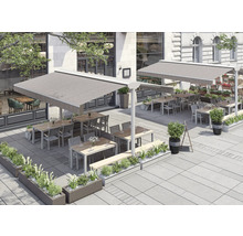 Extérieur d'un restaurant avec des auvents, des tables, des chaises et des jardinières.