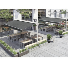 Terrasse avec tables, chaises et stores devant un bâtiment