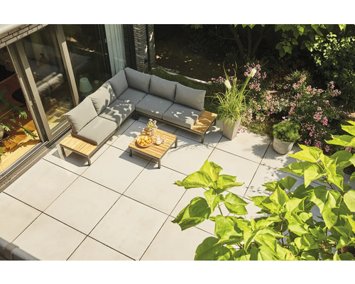 Salon de jardin d'angle moderne en bois et métal avec coussins gris sur une terrasse carrelée claire dans un jardin.