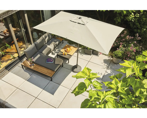 Parasol rectangulaire au-dessus d'une terrasse moderne avec salon de jardin gris, table en bois et dalles claires.