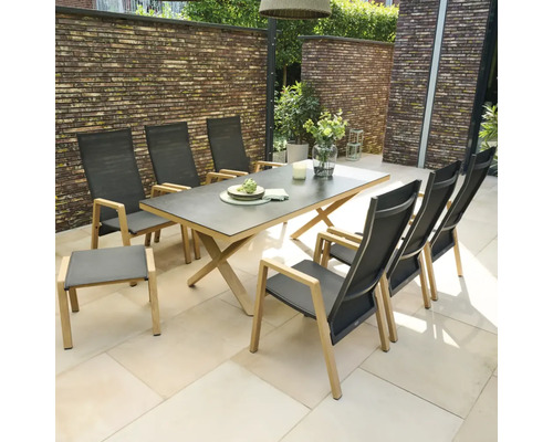 Ensemble de mobilier de jardin comprenant une table avec piètement en bois en X et six chaises à dossier haut en textile gris sur une terrasse.