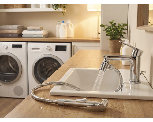 Salle de bain lumineuse avec lavabo, robinet avec flexible de douche et machines à laver