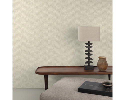 Raumansicht mit gemusterter Tapete, Tisch, Lampe und Dekoration