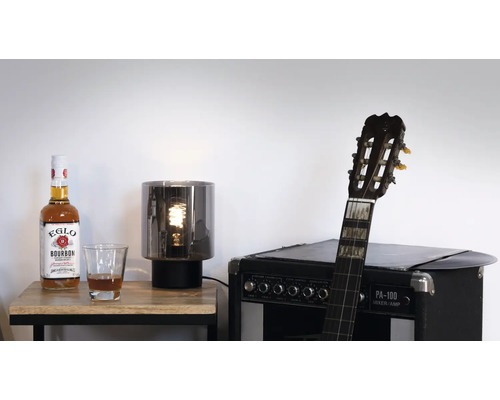 Dekorative Szene mit Flasche, Glas, Lampe und Gitarre