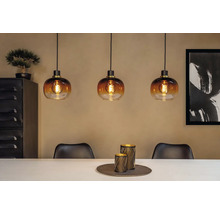 Scène avec trois suspensions en verre au-dessus d'une table à manger