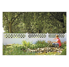 Scène de jardin avec une clôture blanche et une personne nettoyant un bassin