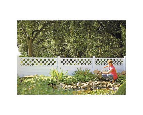 Scène de jardin avec une clôture blanche et une personne nettoyant un bassin